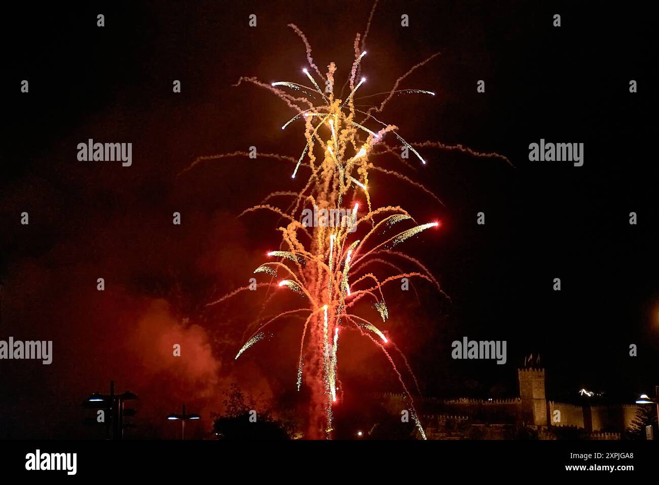 Spektakuläres Feuerwerk während der Fiesta de la Anunciada in Bayona, mit dem historischen Parador als atemberaubender Kulisse. Die lebhaften Explos Stockfoto