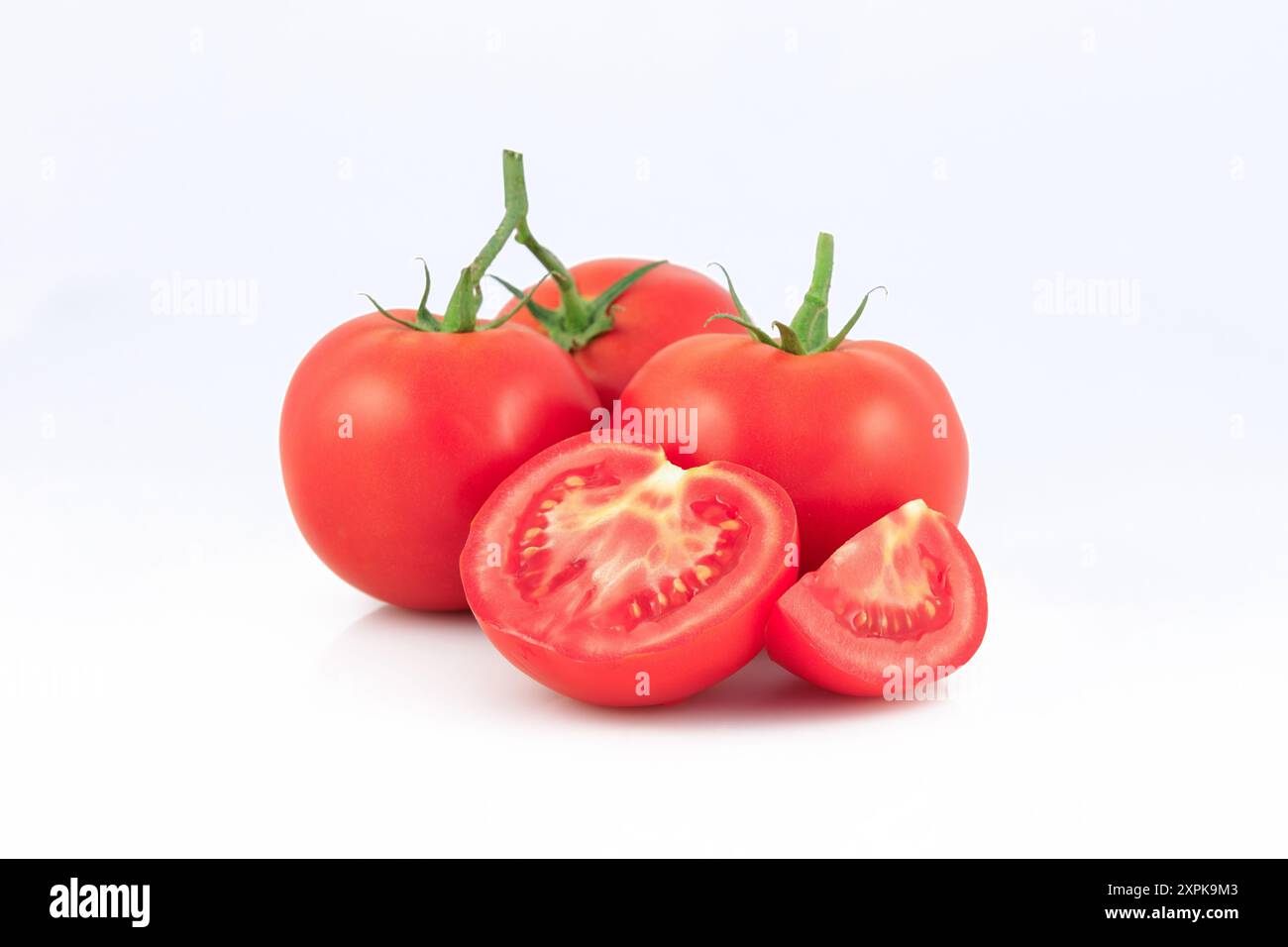 Frische Tomate mit Hälfte und Viertel einer Tomate isoliert auf weißem Hintergrund. Stockfoto