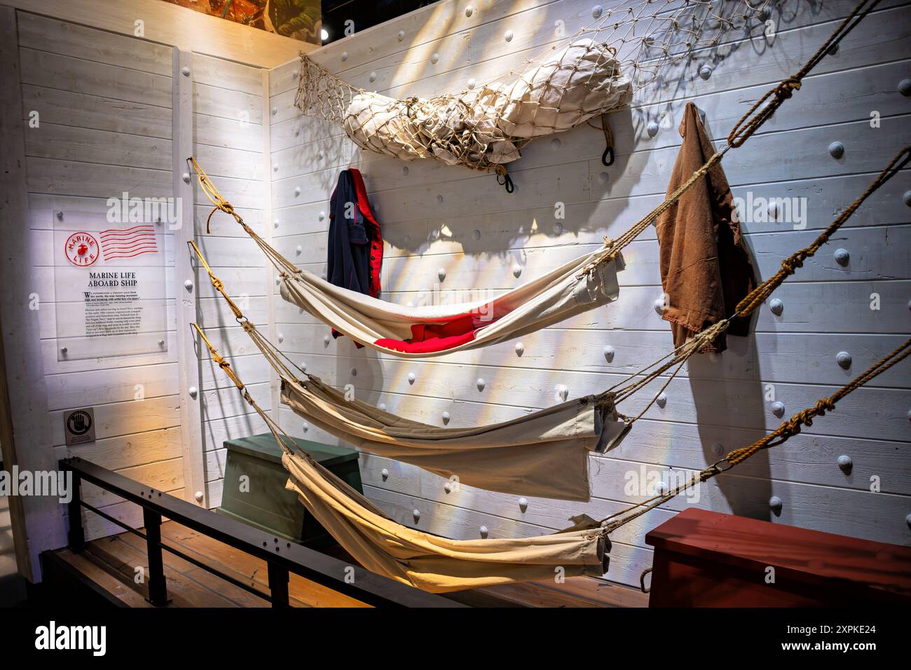 National Museum of the Marine Corps Ship Hängematten Triangle Virginia // TRIANGLE, Virginia — die Ausstellung Marine Life on Board Ship im National Museum of the Marine Corps in Triangle, Virginia, bietet einen Einblick in das tägliche Leben von Marines und Seeleuten, die im frühen 19. Jahrhundert auf Marinekriegschiffen dienten. Die Ausstellung zeigt die engen Viertel und die schwierigen Bedingungen an Bord der „Frigate Navy“, wo die engagierten Männer in Hängematten aus Segeltuch zwischen Schottenhaken schliefen und inmitten der ständigen Bewegung des Meeres lebten. Die Ausstellung erkundet auch die ergreifende Begräbnis in der Tradition des Meeres, wo verstorbene Sai Stockfoto