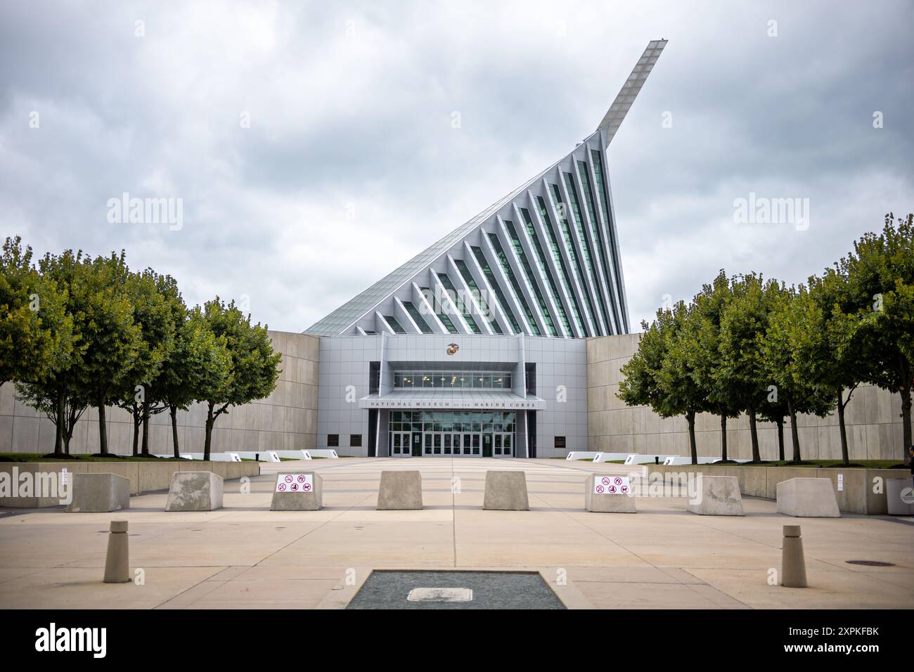 National Museum of the Marine Corps Tower Triangle Virginia // TRIANGLE, Virginia, Vereinigte Staaten — der markante Turm des National Museum of the Marine Corps erhebt sich über den Bäumen in Triangle, Virginia. Der 210 m hohe, geneigte Stahlmast, der durch ein hoch aufragendes Glasatrium führt, erinnert an das ikonische Bild der Marines, die während des Zweiten Weltkriegs die Flagge auf Iwo Jima hissen. Dieses architektonische Herzstück des Museums, das im November 2006 eröffnet wurde, ist zu einem Wahrzeichen entlang des I-95-Korridors in der Nähe von Quantico geworden. Stockfoto