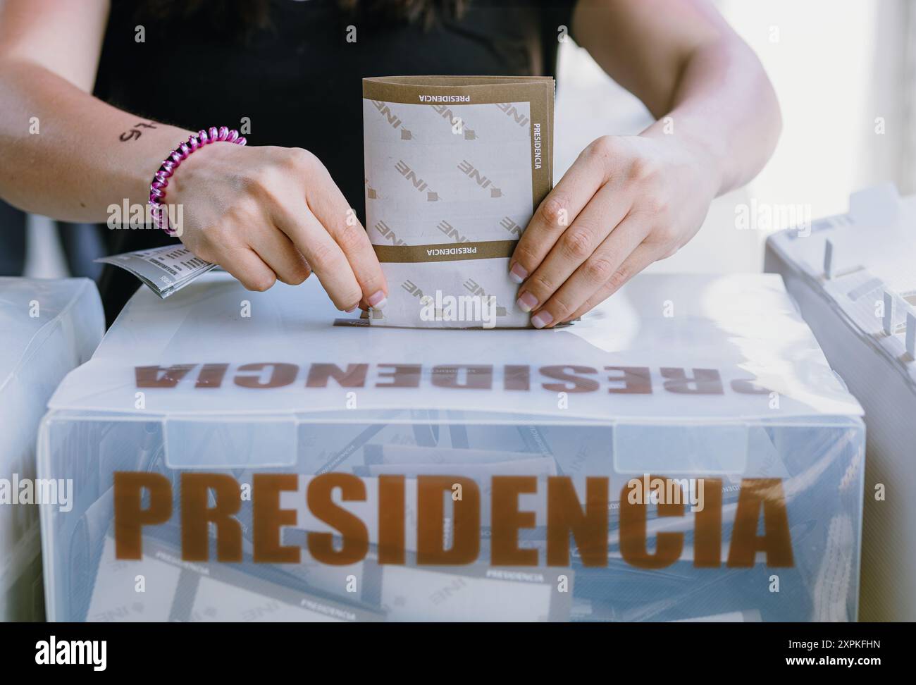 Eine Person legt ihre Stimmzettel während der mexikanischen Präsidentschaftswahlen in die Box und hält damit einen bedeutsamen Moment im Wahlprozess fest. Das Bild hoch Stockfoto