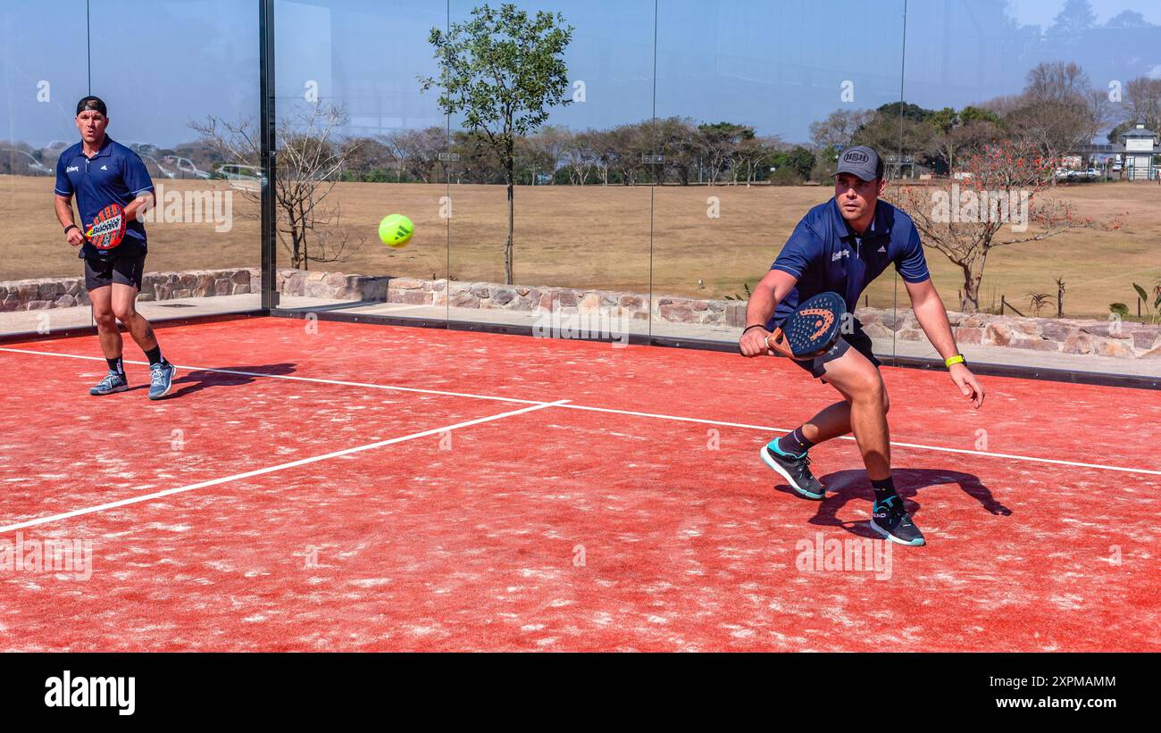Das Padel Tennis-Action-Team verdoppelt die Spieler auf einem Platz mit Glaswänden im Freien. Stockfoto