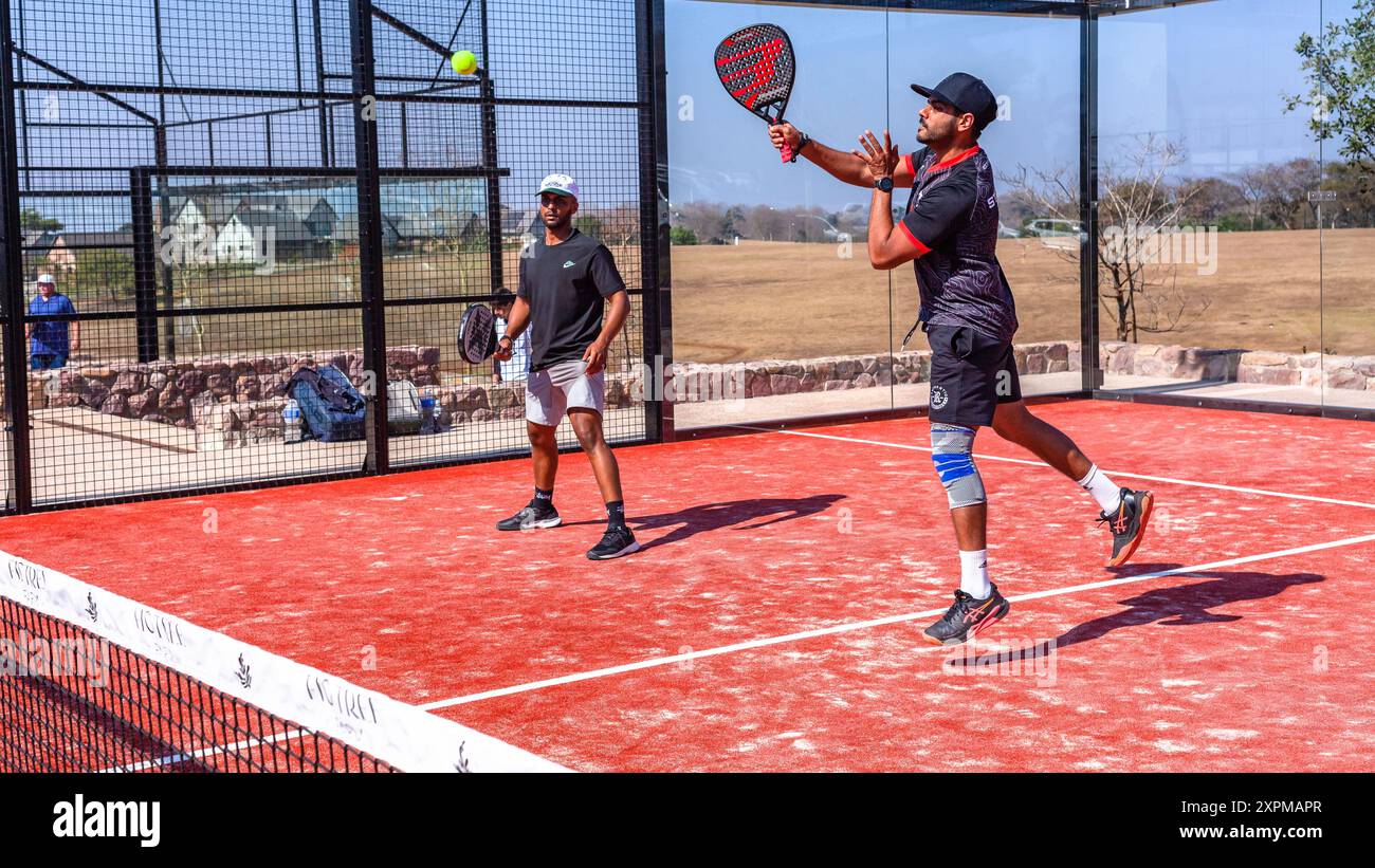 Das Padel Tennis-Action-Team verdoppelt die Spieler auf einem Platz mit Glaswänden im Freien. Stockfoto