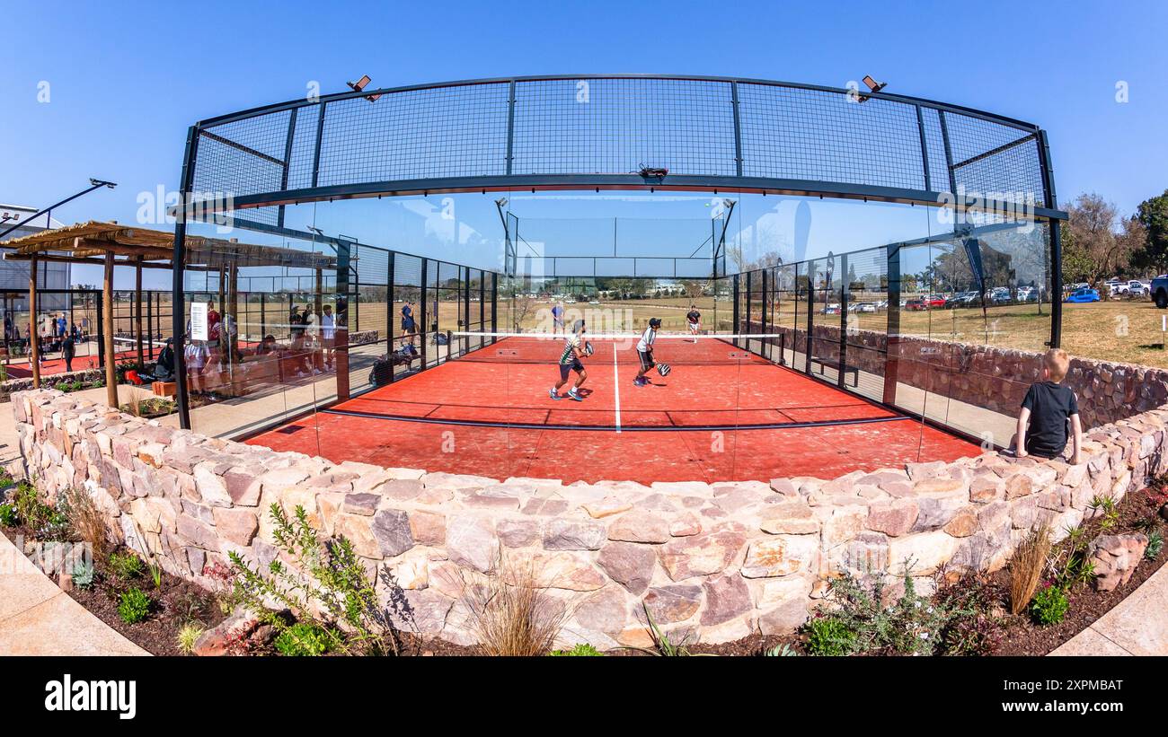 Das Padel Tennis-Action-Team verdoppelt die Spieler auf einem Astro-Platz im Freien mit Glasmauern im Freien. Stockfoto