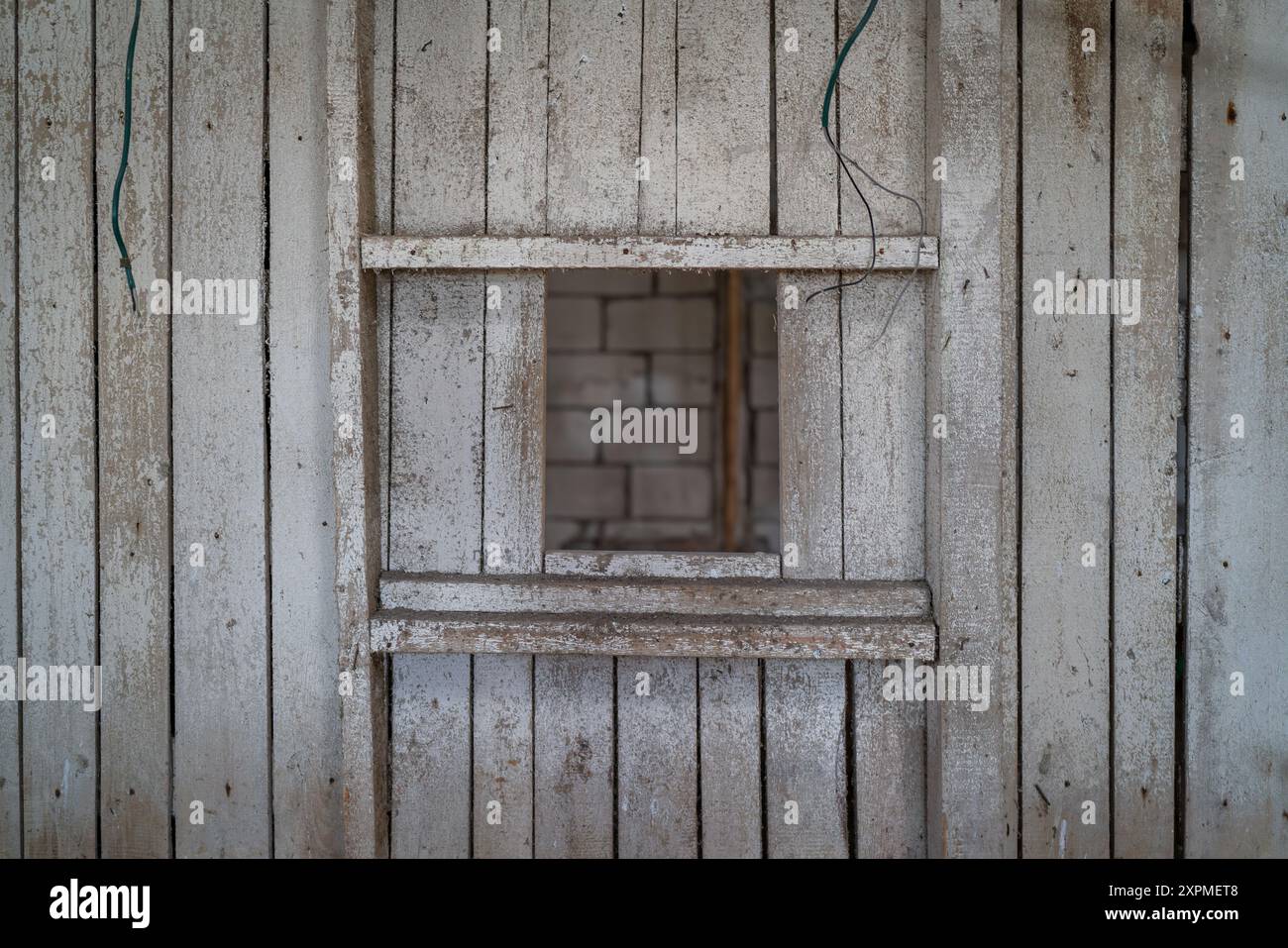 Innenraum einer verlassenen Fischfabrik mit Holzwand. Weiß getünchte Wände im alten Fabrikgebäude. Stockfoto