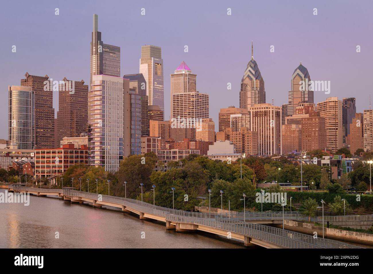 Philadelphia Downtown Skyline mit dem Schuylkill River. Wunderschönes Sonnenuntergangslicht. Schuylkill River Trail im Hintergrund. Die Skyline der Stadt leuchtet unter der Be Stockfoto