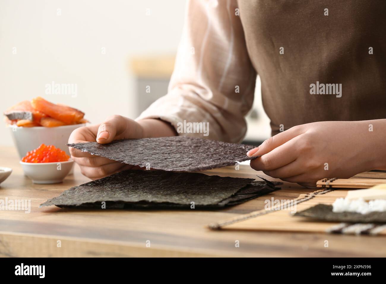 Eine Frau, die köstliche Sushi-Brötchen zubereitet, Nahaufnahme Stockfoto