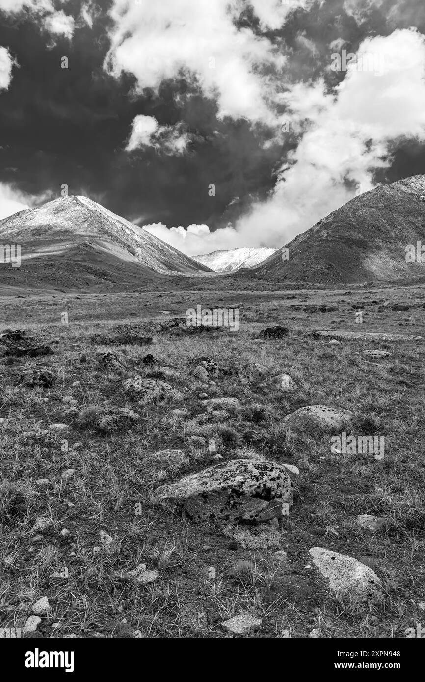 Landschaft mit einem hochgelegenen Bergpass namens Warila in Schwarz-weiß mit Felsen im Vordergrund in Ladakh, Indien. Stockfoto