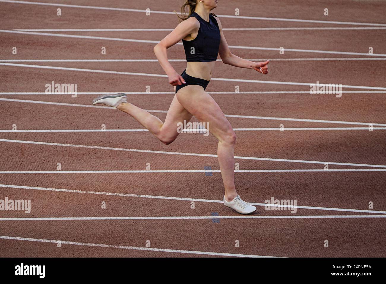 Weibliche Athletinnen, die Sprintrennen vor dem Hintergrund sich kreuzender Markierungslinien laufen Stockfoto