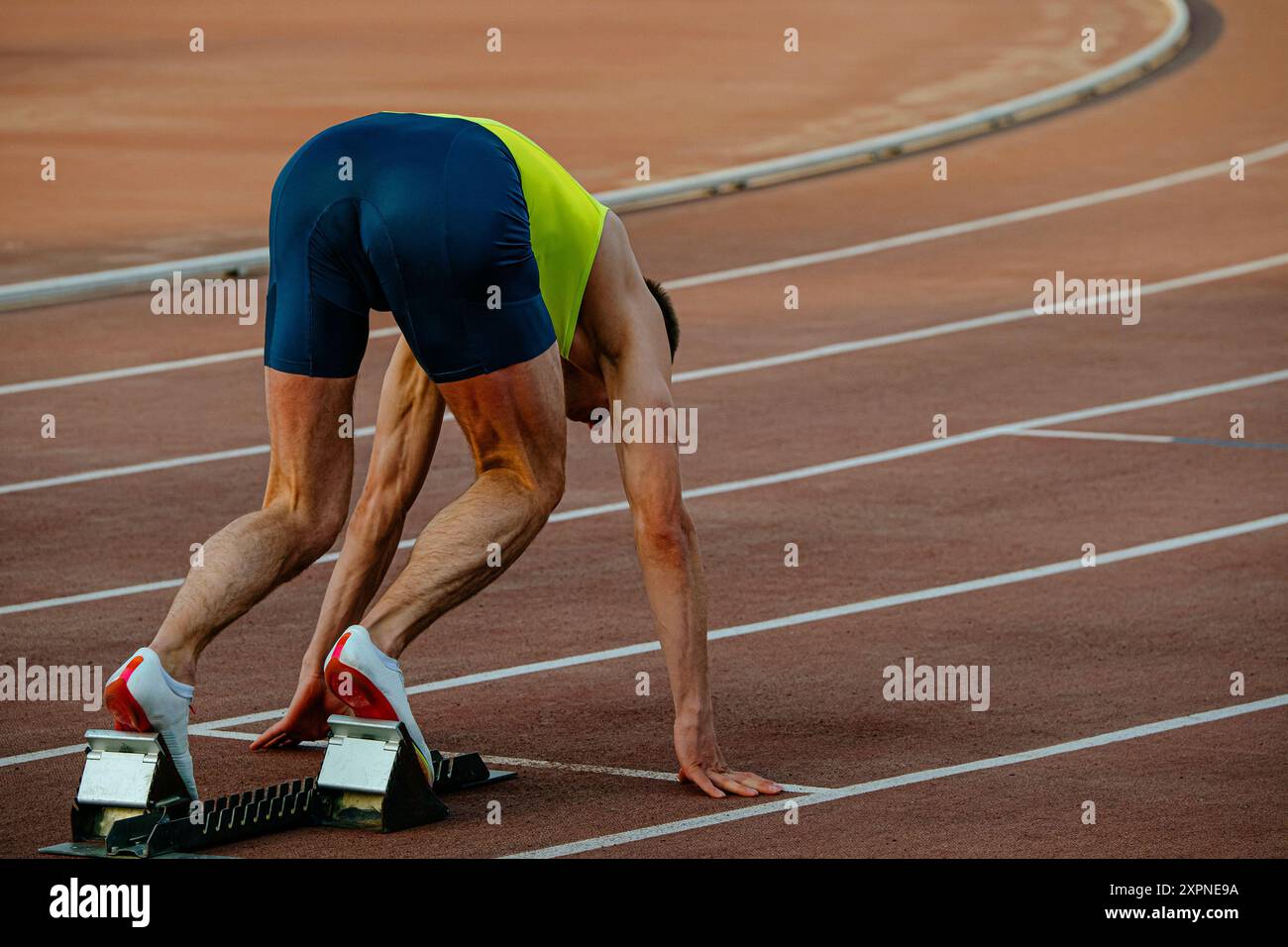 Männlicher Läufer in Startblöcken Sprint-Rennen Stockfoto