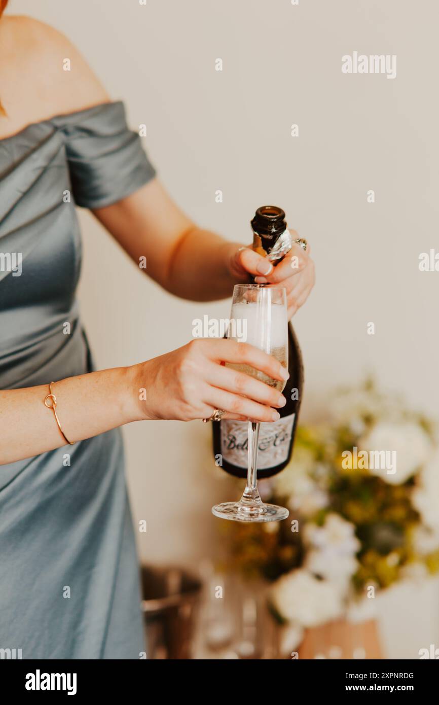 Frau, die Wein in einer Hochzeitsdekoration gießt Stockfoto