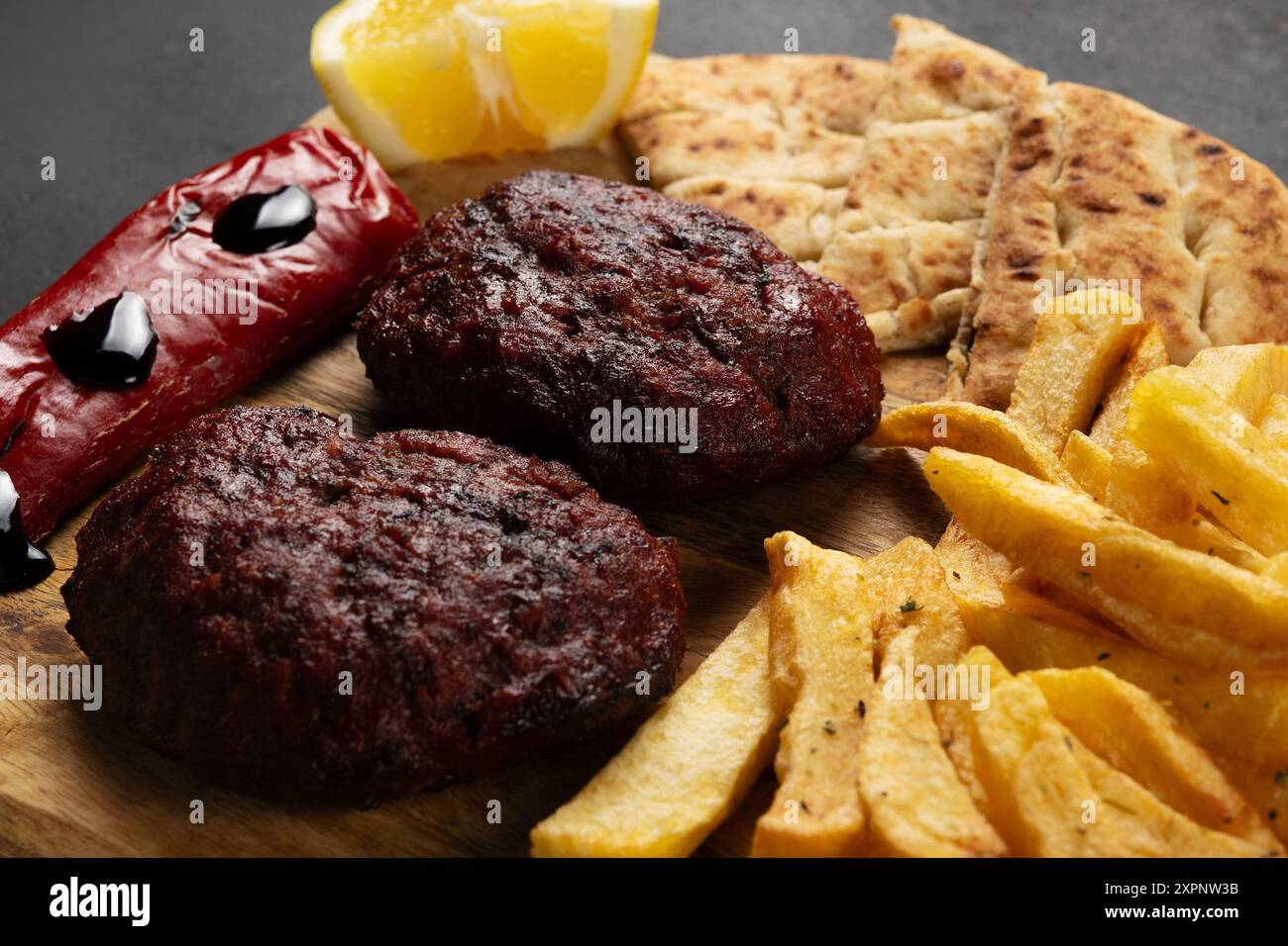 Griechische mediterrane Küche. XL-Rindfleisch aus Hackfleisch mit frittierten Kartoffeln, Pfeffer, Pita und Joghurt-Dip. Stockfoto