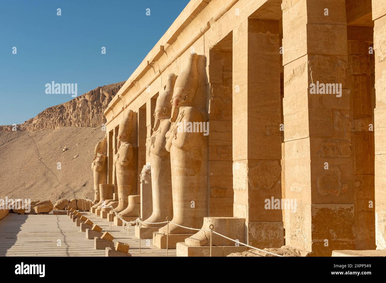 Die Säulen des Tempels der Hatschepsut in Luxor sind mit Statuen des Pharao geschmückt. Dieses architektonische Meisterwerk ist ein Zeugnis der Reichen. Stockfoto
