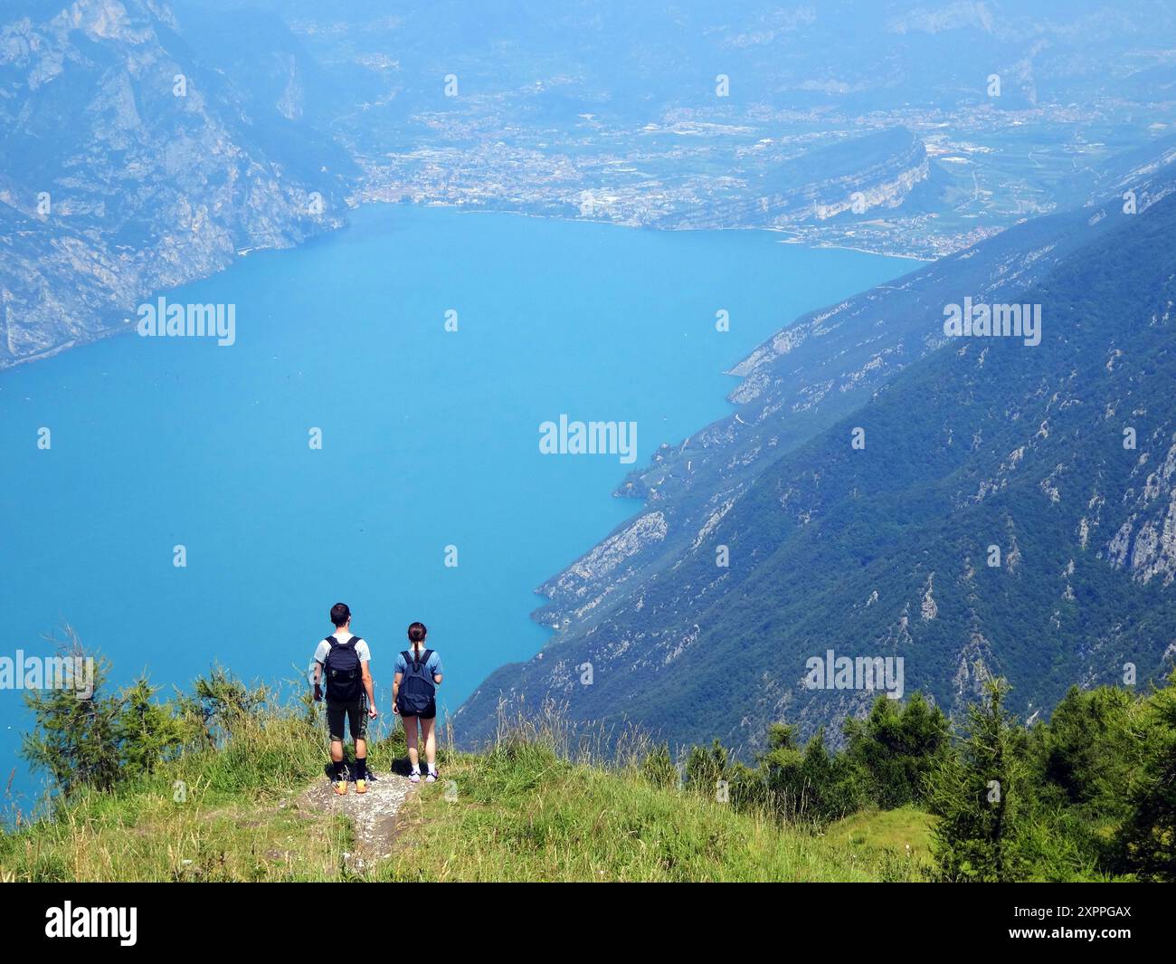 Ein Paar schaut von einer Bergseite über der Stadt Malcesine auf den nördlichen Teil des Gardasees in Norditalien. Stockfoto