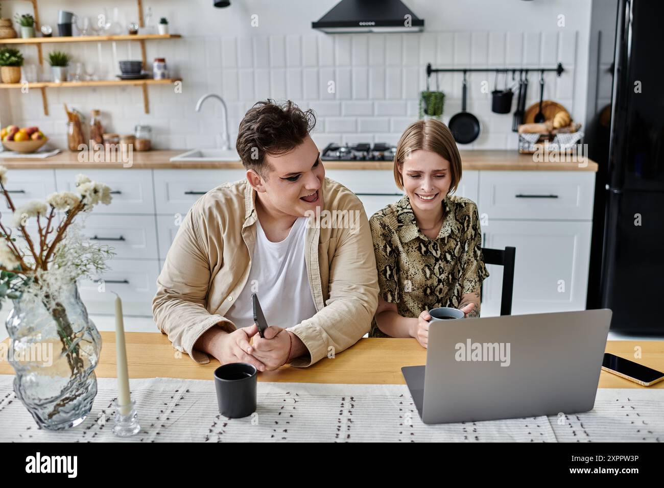 Ein freudiger Moment, der sich über einen Laptop in einer modernen Küche geteilt hat. Stockfoto