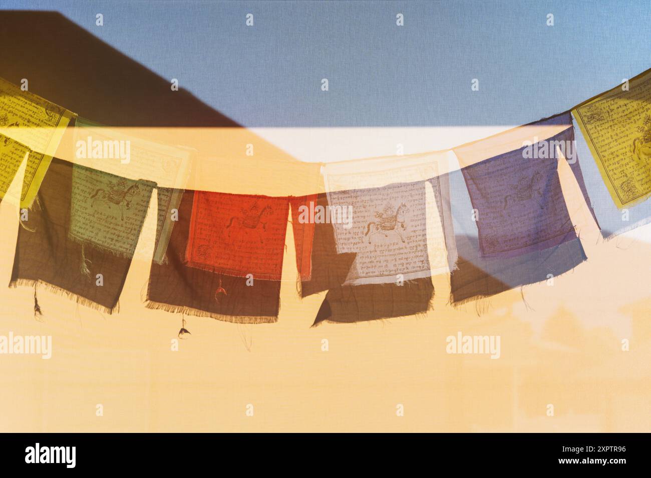 Sonne wirft Schatten der traditionellen buddhistischen Gebetsfahnen auf ein Windschutz Stockfoto