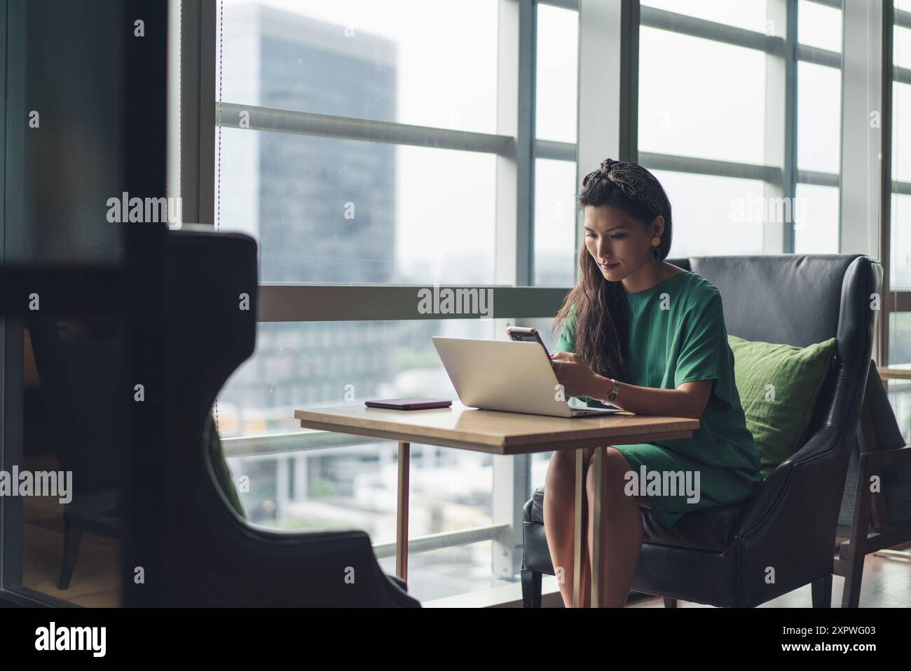 Asiatische Geschäftsfrau, die Hot Desking machte und mit der Arbeit beschäftigt war Stockfoto