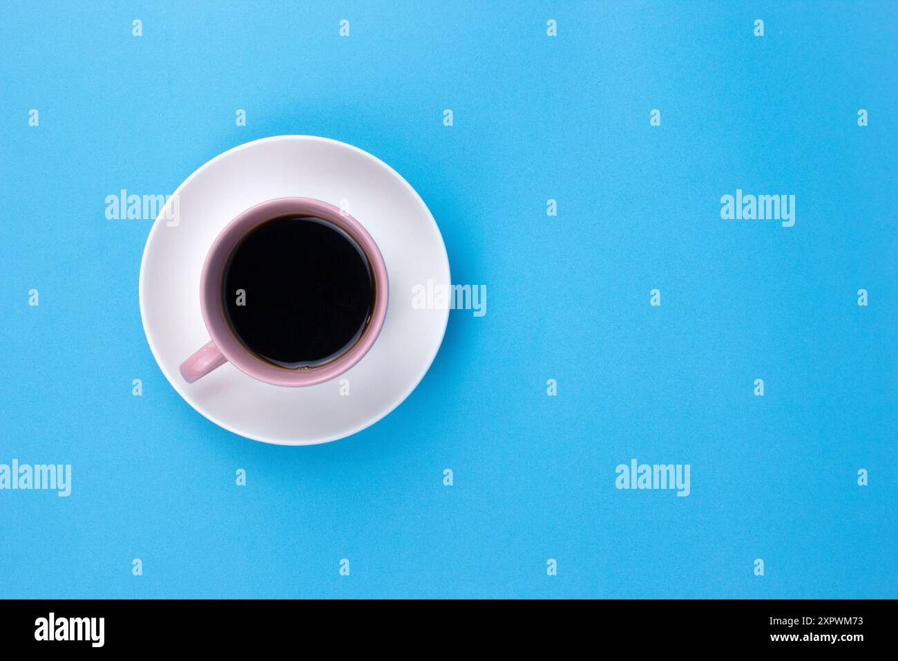 Ein isolierter schwarzer Kaffee auf hellrosa Jungtier auf hellblauem Hintergrund Stockfoto