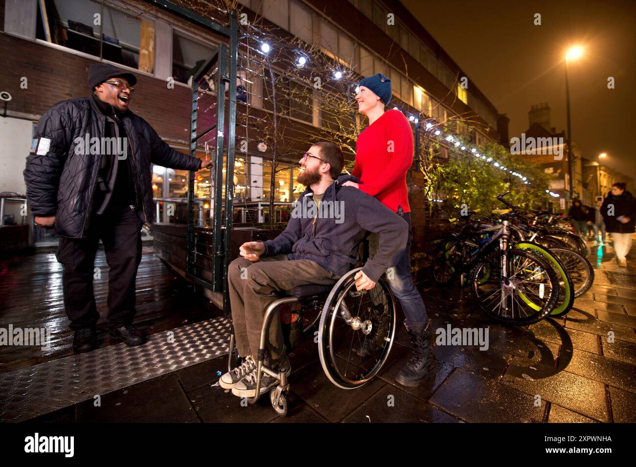 Ein junger behinderter Mann besucht einen rollstuhlgerechten Musikort in Großbritannien. Stockfoto