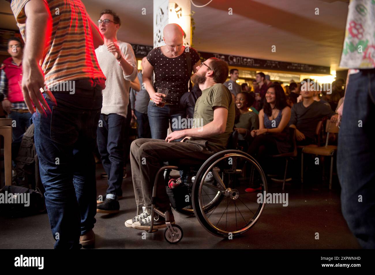 Ein junger behinderter Mann besucht einen rollstuhlgerechten Musikort in Großbritannien. Stockfoto