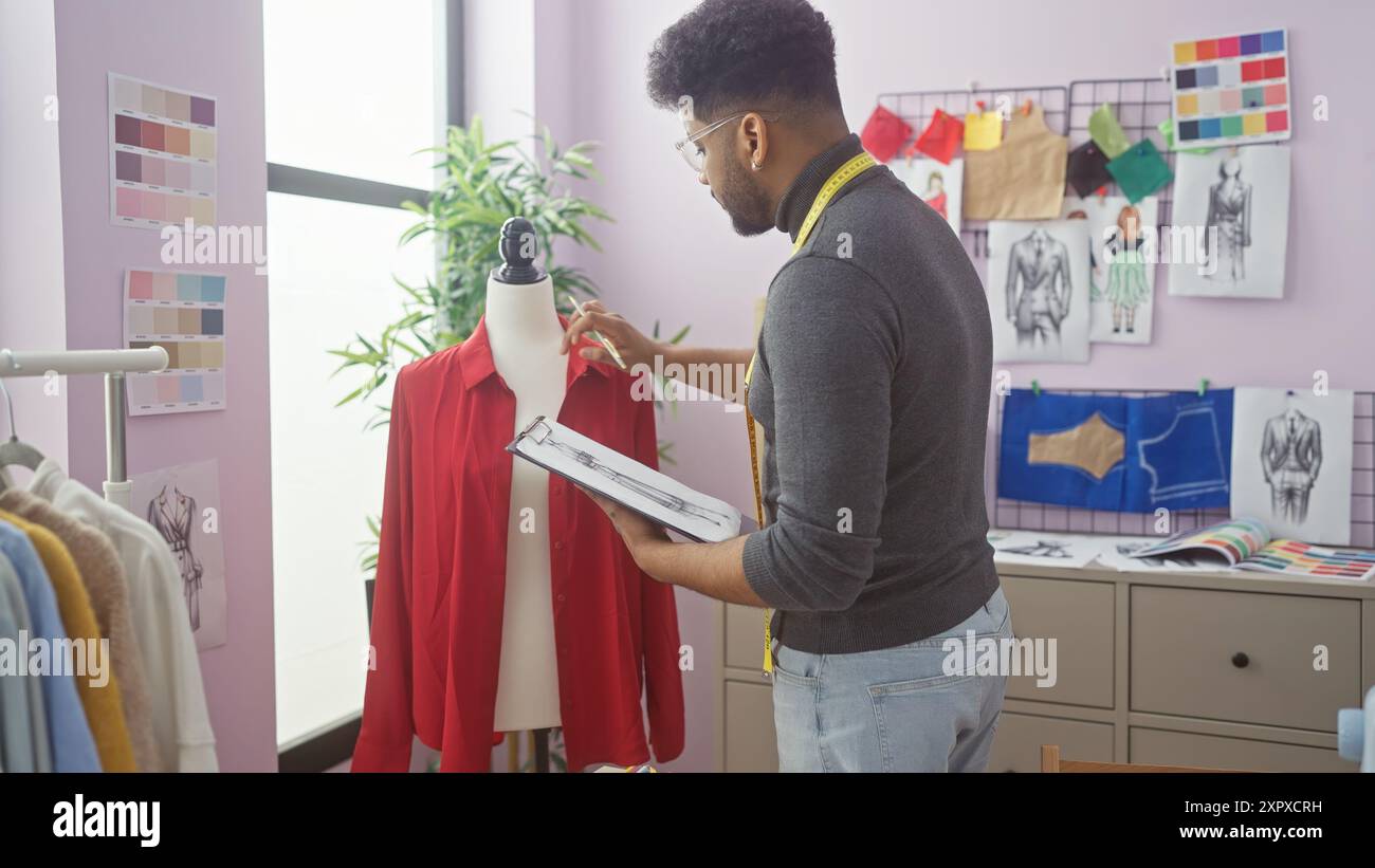 afroamerikaner in einem Schneiderladen, der eine Schaufensterpuppe misst, umgeben von Modeskizzen und Stoffproben. Stockfoto