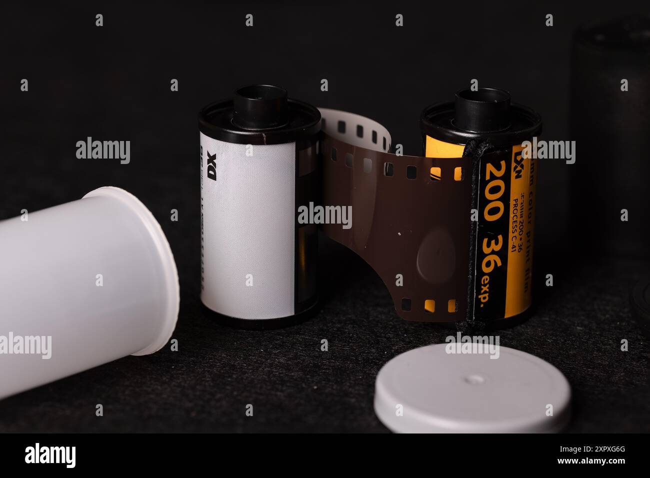 Detaillierte Ansicht von 35-mm-Filmrollen vor dunklem Hintergrund, die das Wesen der analogen Fotografie mit einem zeitlosen Gefühl festhalten. Stockfoto