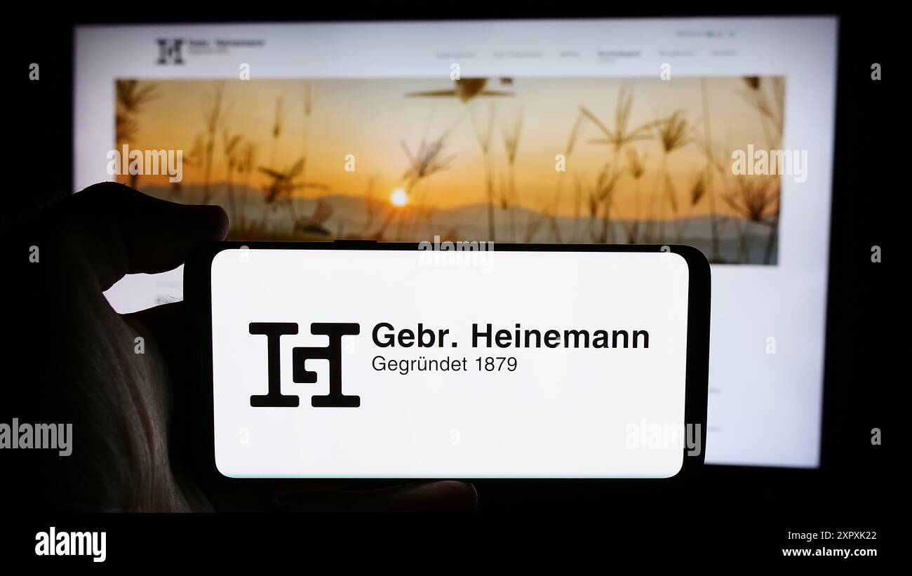 Person mit Mobiltelefon mit Logo des deutschen Reiseveranstalters Gebr. Heinemann SE Co. KG vor der Webseite. Schwerpunkt auf dem Display des Telefons. Stockfoto Person mit Mobiltelefon mit Logo des deutschen Reiseveranstalters Gebr. Heinemann SE Co. KG vor der Webseite. Schwerpunkt auf dem Display des Telefons. Stockfoto