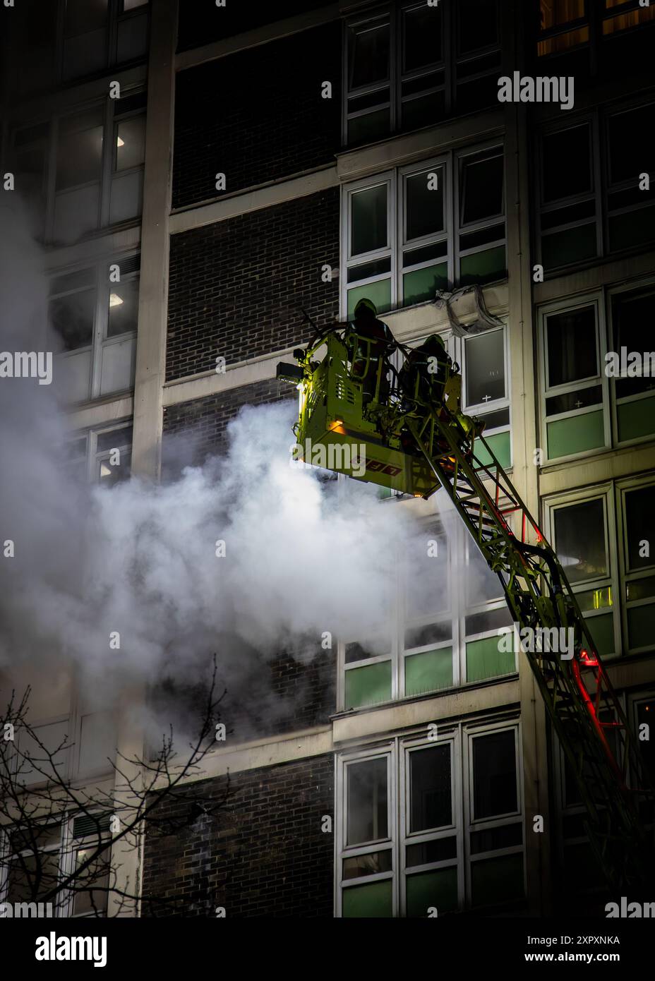 Ein in Brand geratener Londoner Wohnturm wird von der Londoner Feuerbrigade beaufsichtigt Stockfoto