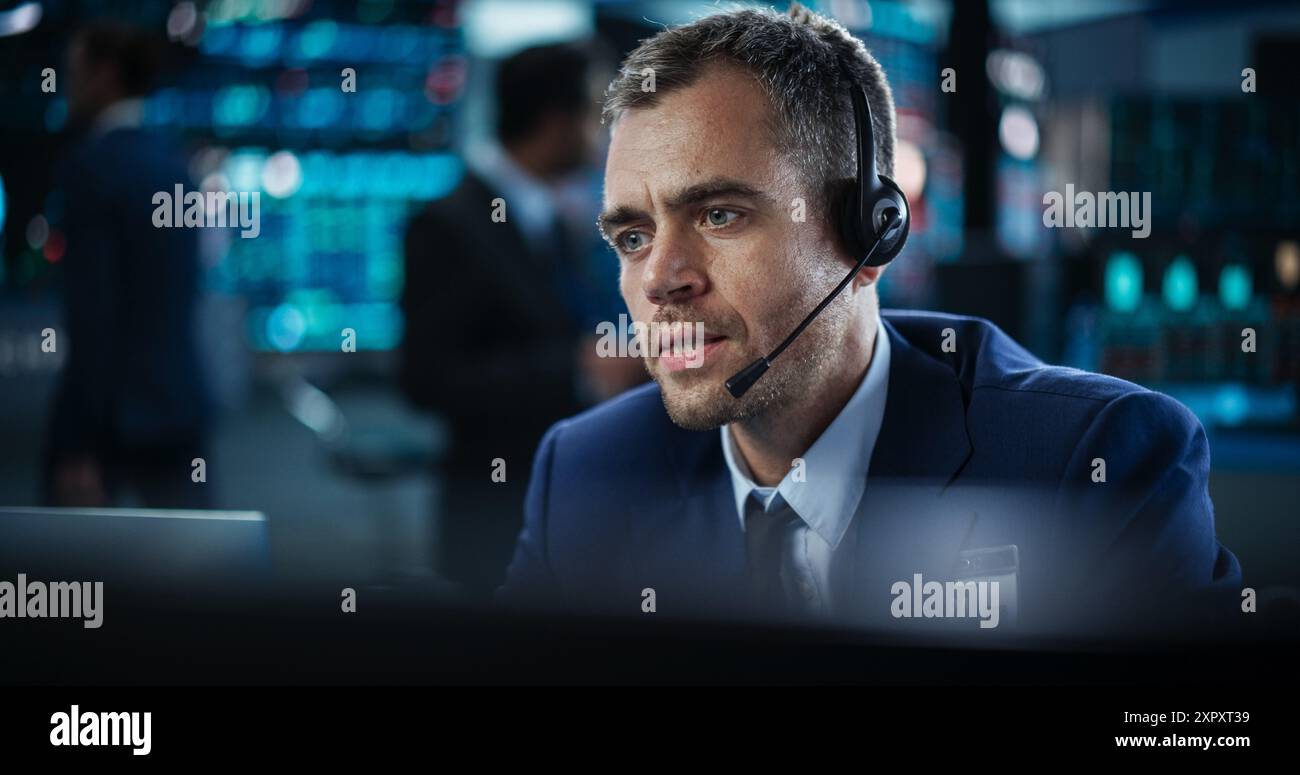 Porträt eines Finanzanalysten mit einem Desktop-Computer mit Echtzeit-Diagrammen, Finanzberichten und Marktaktualisierungen. Händler, der an einer modernen Börse arbeitet und mit Brokern kommuniziert Stockfoto