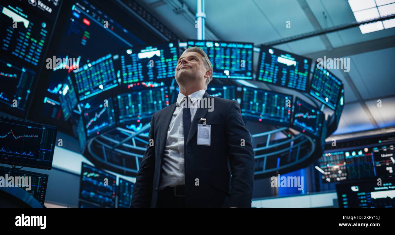 Börsenhändler arbeitet an einer Börse mit Multi-Monitor-Konfiguration mit Echtzeitinvestitionen, Rohstoffe und Devisenfonds. Glücklicher Geschäftsmann, der einen erfolgreichen Handel feiert Stockfoto