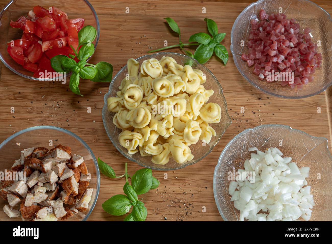 Zwiebeln, Speck, Hackfleisch und Tortellini sind die Zutaten für einen Tortelini-Salat Stockfoto