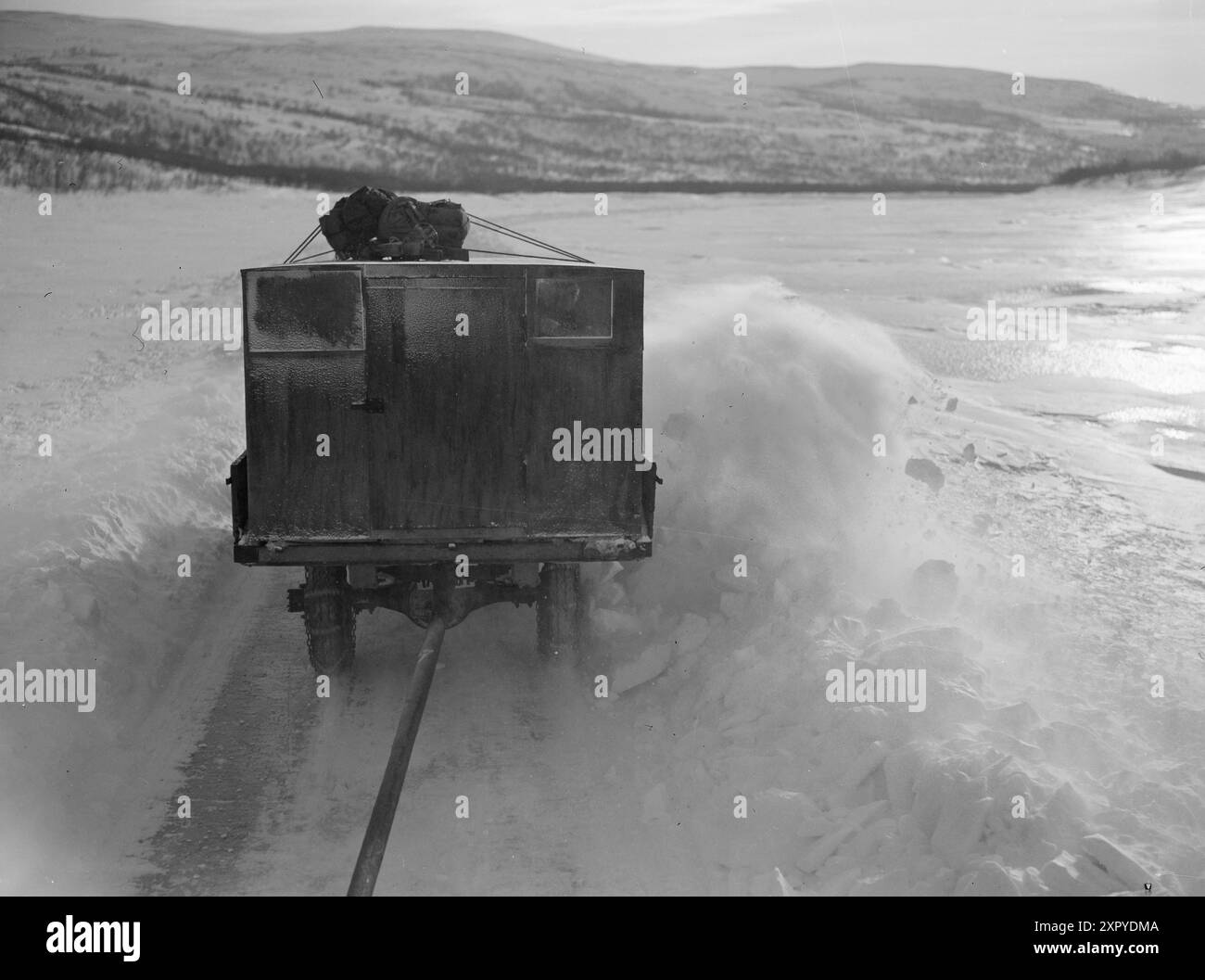 Aktuell 10-1949: Die unglaublichste Winterwagenstrecke der Welt die unglaublichste Winterwagenstrecke der Welt - es ist die Teststrecke, die diesen Winter den Abschnitt Skippagurra - Karasjok in Finnmark umfasste und die das Eis auf dem Fluss Tana als Straße nutzte. - Das ist die mächtige Tanaelva, die diesen Winter als "Straße" für eine experimentelle Busroute zwischen Skipagurra und Karasjok benutzt wurde. Tana hat nur wenige Stromschnellen und war schon immer eine wichtige Route für Flussschiffe im Sommer und Rentierräuber und Pferdekutschen im Winter. Aber der Wind nimmt zu, und eine gepflügte Straße ist leicht zu befahren Stockfoto