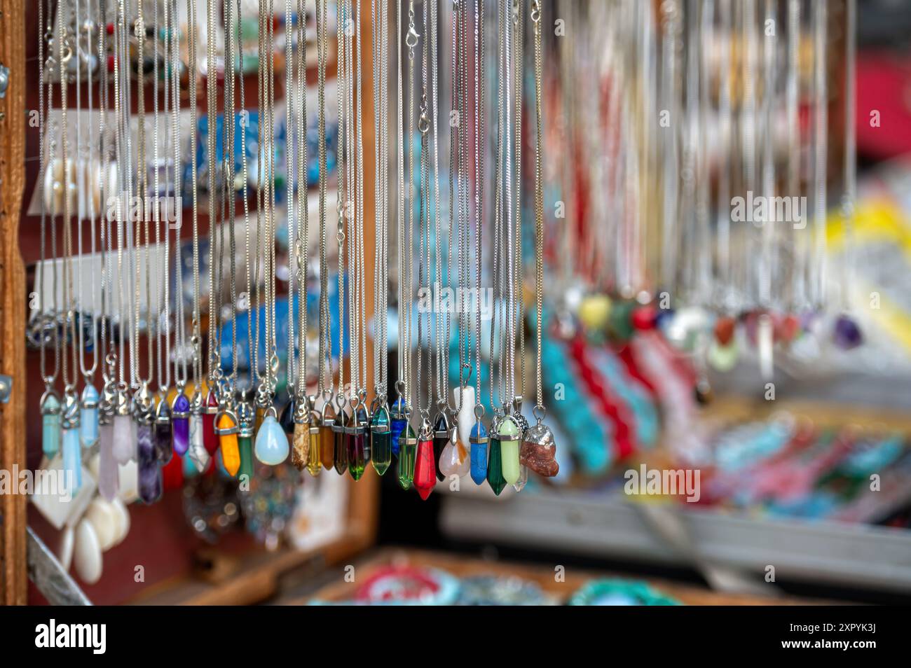 Lebendige Halsketten und Anhänger hängen auf einem lokalen Kunsthandwerksmarkt. Stockfoto