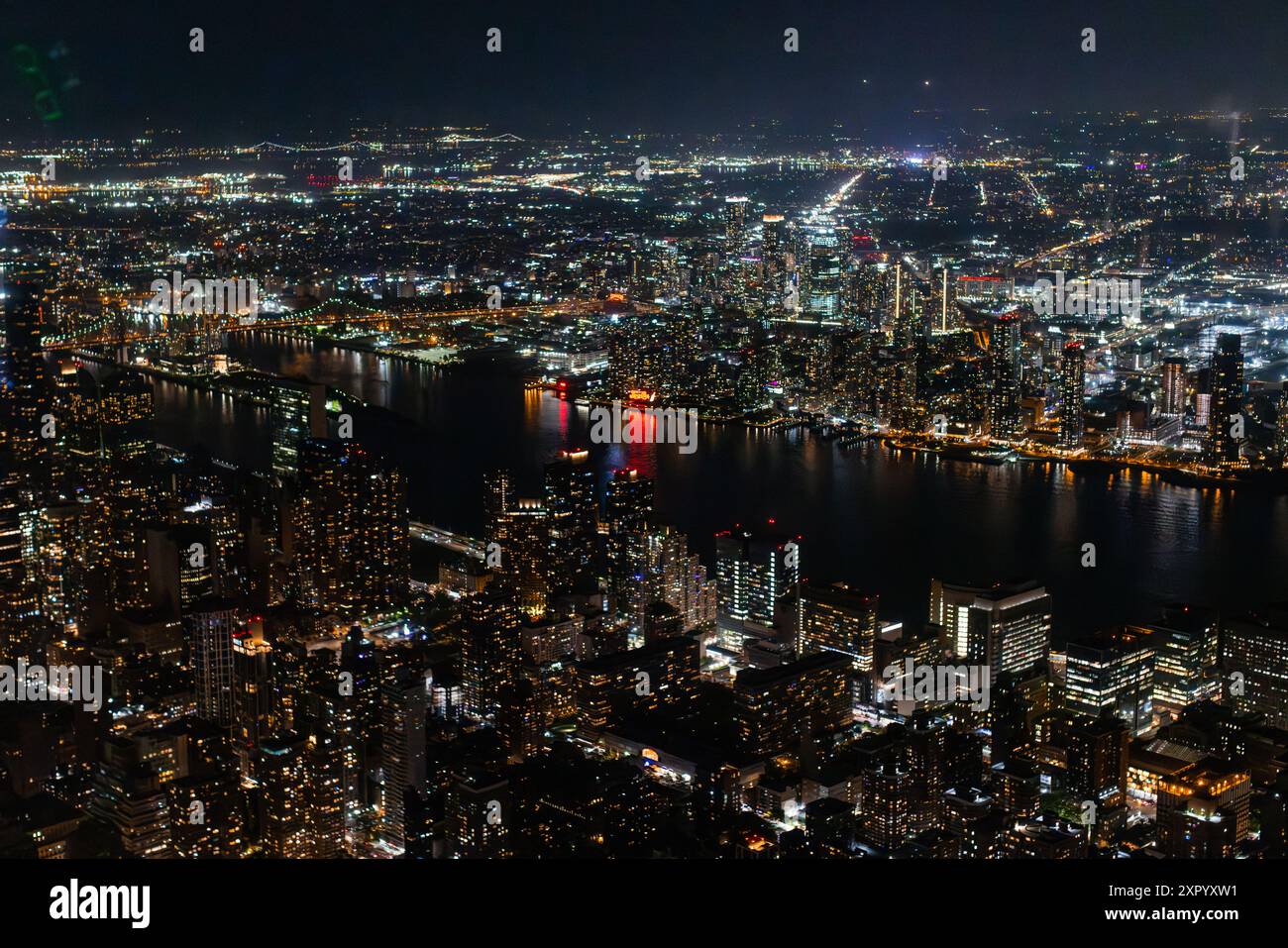 Nachtfoto mit Wolkenkratzern in New York City mit Lichtern in Büroräumen im Inneren. Helikopter-Ansicht mit Panoramablick auf Manhattan Stockfoto