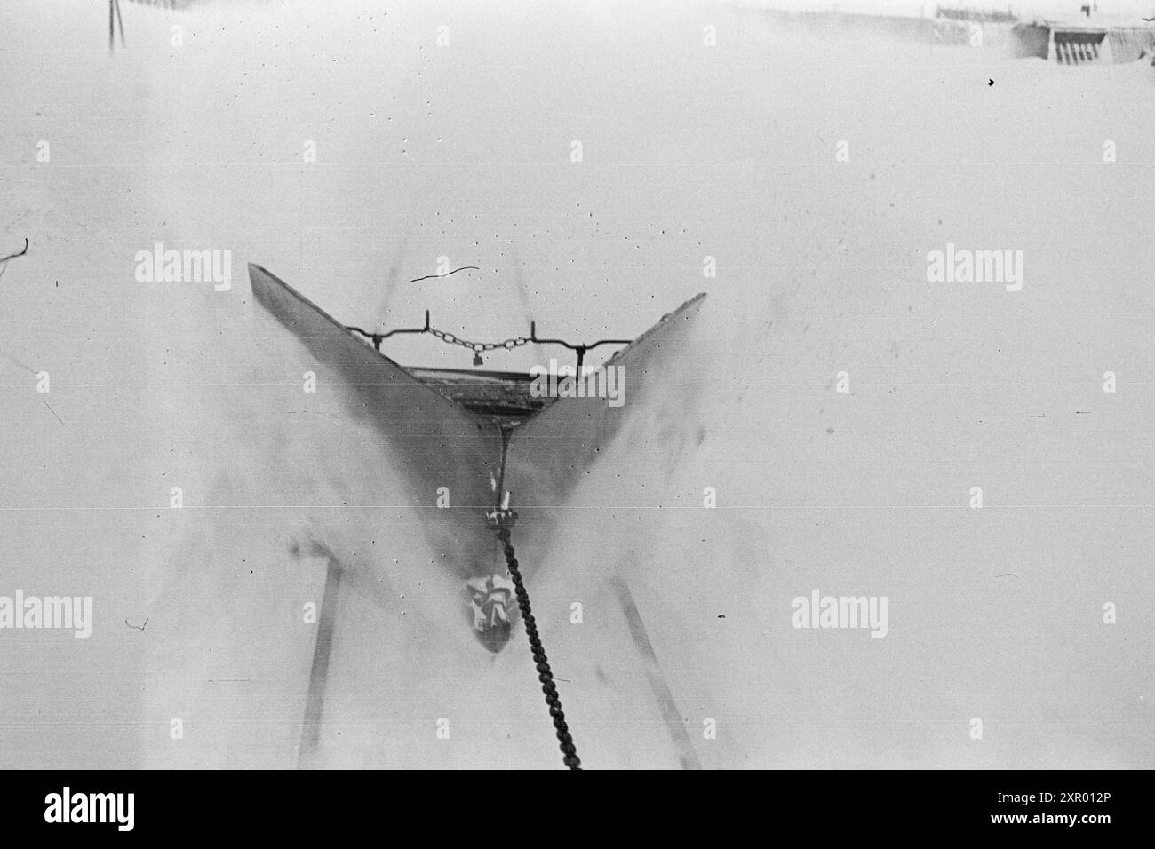 Tatsächlich 1948: Schneeräumung auf der Bergen Railway. Die Bergen Railway, eine der wichtigsten Eisenbahnlinien Norwegens, erreicht ihren höchsten Punkt westlich von Finse auf 1301 Metern über dem Meeresspiegel. Wind und Schnee sorgen hier dafür, dass es nicht immer so einfach ist, diese Strecke im Winter offen zu halten. Nachdem der rotierende Schneepflug und der „Scraper“ die Linie bearbeitet haben, wird eine schöne und gleichmäßige Straße ausgegraben. Aber die Gleise sind dann mehr oder weniger mit Schnee bedeckt. Jetzt ist es Zeit für den Kettenreiniger, der so konstruiert ist, dass er tief genug zwischen den Schienen gräbt und sie auch von Schnee reinigt. Die Spur Stockfoto