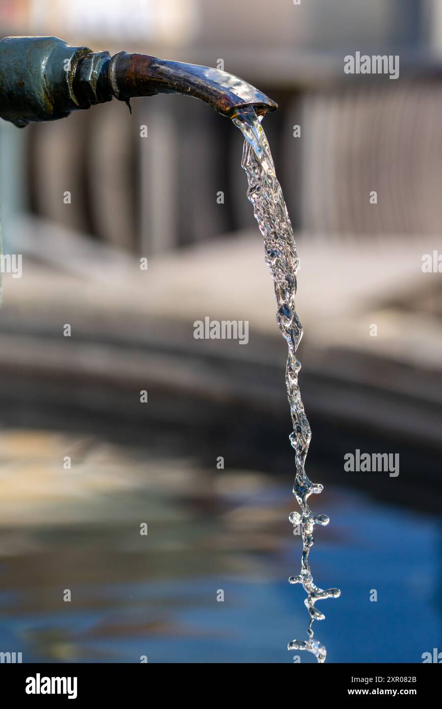 Trinkwasser fließt aus dem Wasserhahn eines Stadtbrunnens. Stockfoto