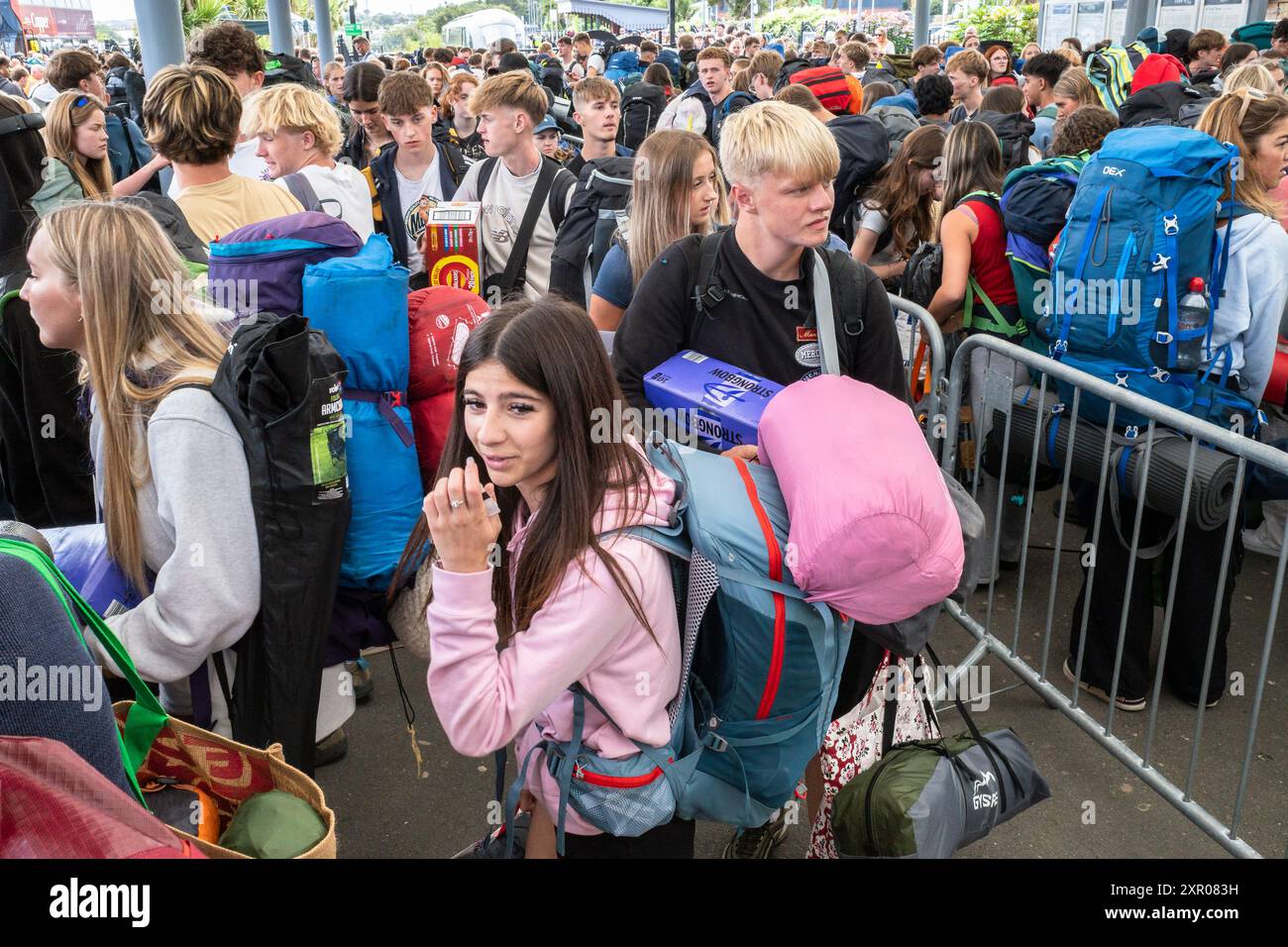 Einige der 1400 aufgeregten jungen Leute standen geduldig in der Warteschlange, nachdem sie mit einem Zug am Bahnhof Newquay zum Boardmasters Festival in Newquay angekommen waren Stockfoto