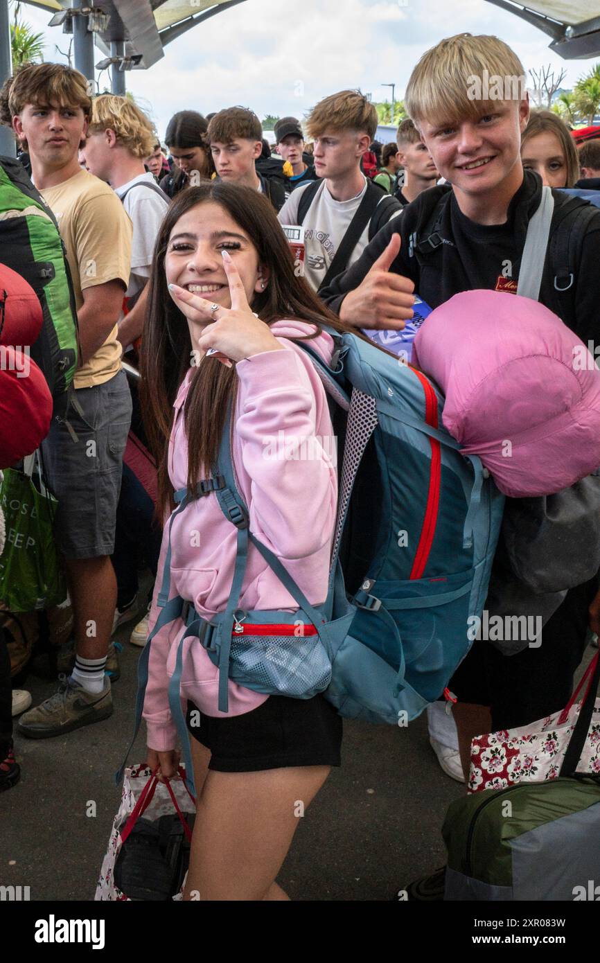 Einige der 1400 aufgeregten jungen Leute standen geduldig in der Warteschlange, nachdem sie mit einem Zug am Bahnhof Newquay zum Boardmasters Festival in Newquay angekommen waren Stockfoto