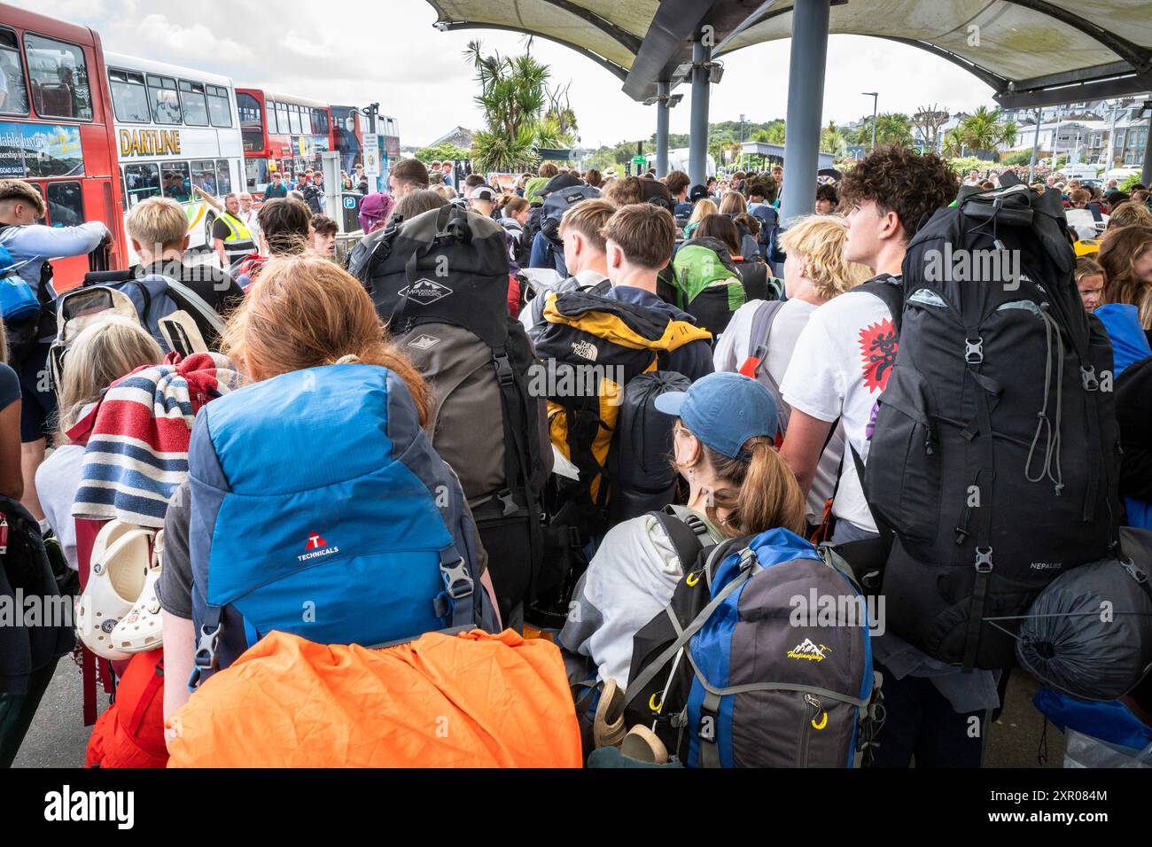 Einige der 1400 aufgeregten jungen Leute standen geduldig in der Warteschlange, nachdem sie mit einem Zug am Bahnhof Newquay zum Boardmasters Festival in Newquay angekommen waren Stockfoto