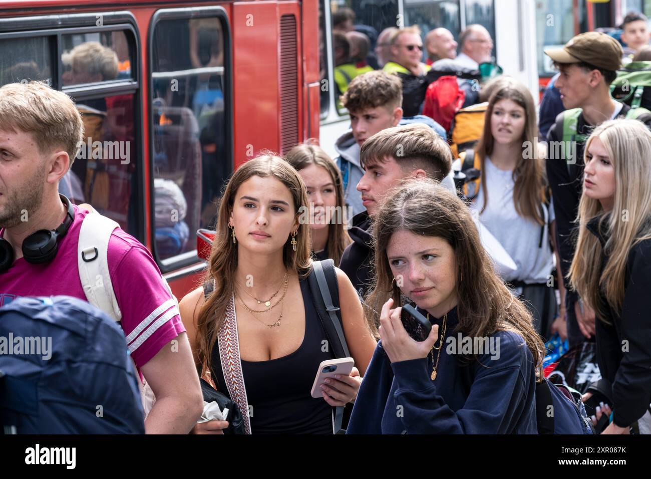 Einige der 1400 aufgeregten jungen Leute standen geduldig in der Warteschlange, nachdem sie mit einem Zug am Bahnhof Newquay zum Boardmasters Festival in Newquay angekommen waren Stockfoto