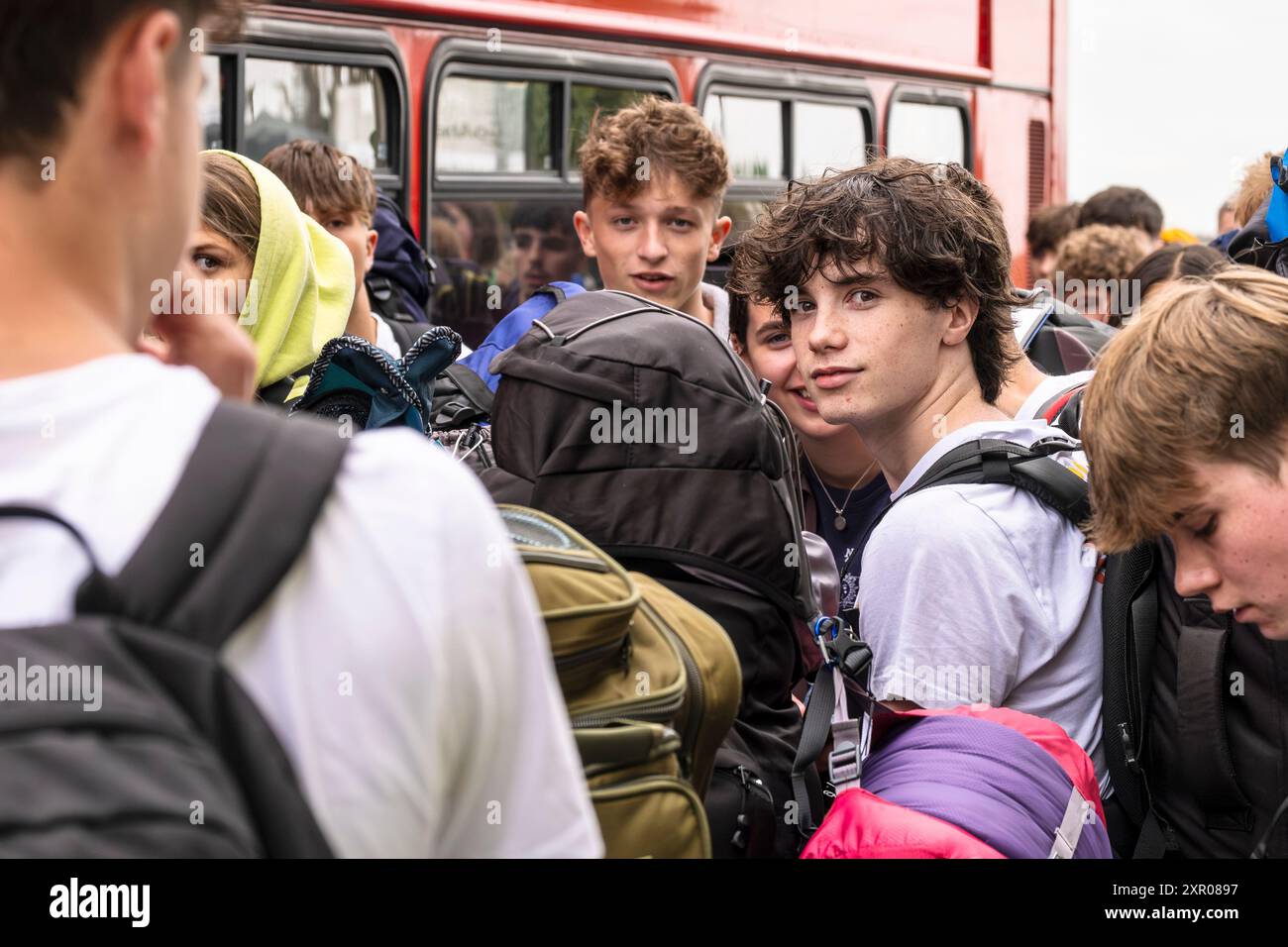 Einige der 1400 aufgeregten jungen Leute standen geduldig in der Warteschlange, nachdem sie mit einem Zug am Bahnhof Newquay zum Boardmasters Festival in Newquay angekommen waren Stockfoto