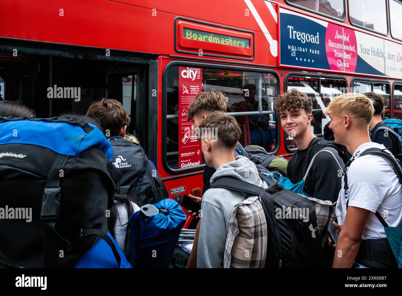 Einige der 1400 aufgeregten jungen Leute standen geduldig in der Warteschlange, nachdem sie mit einem Zug am Bahnhof Newquay zum Boardmasters Festival in Newquay angekommen waren Stockfoto