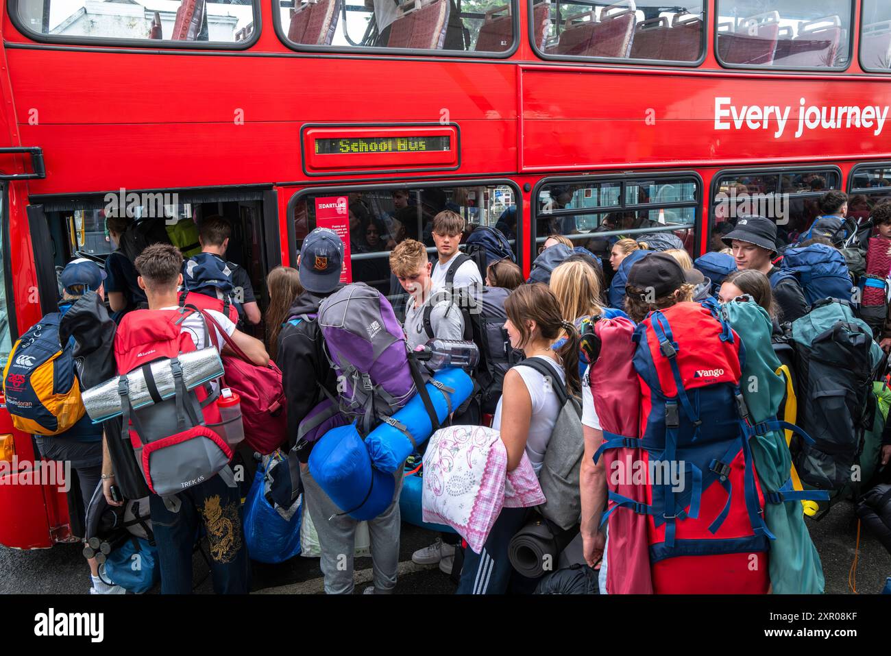 Einige der 1400 aufgeregten jungen Leute standen geduldig in der Warteschlange, nachdem sie mit einem Zug am Bahnhof Newquay zum Boardmasters Festival in Newquay angekommen waren Stockfoto