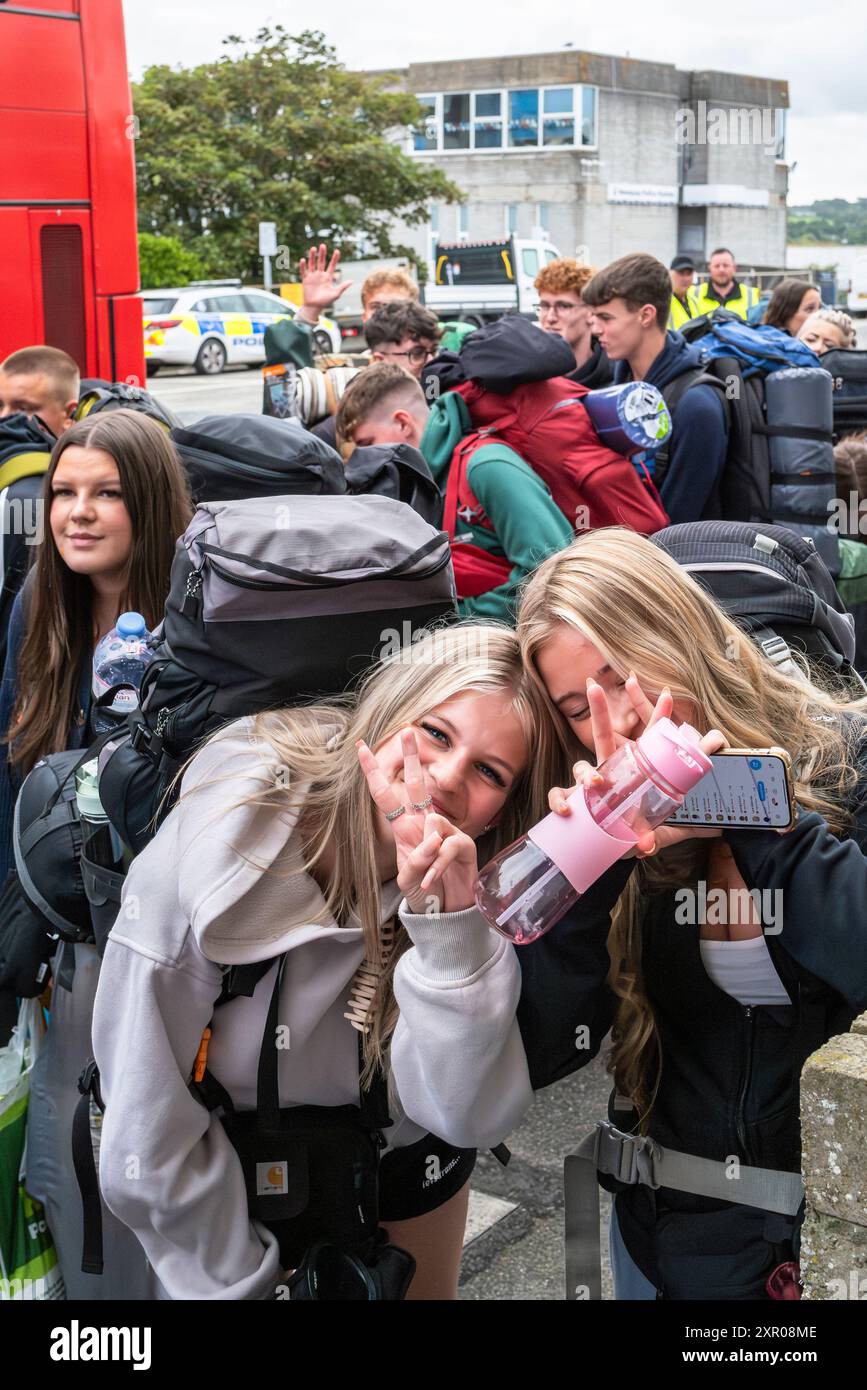 Einige der 1400 aufgeregten jungen Leute standen geduldig in der Warteschlange, nachdem sie mit einem Zug am Bahnhof Newquay zum Boardmasters Festival in Newquay angekommen waren Stockfoto