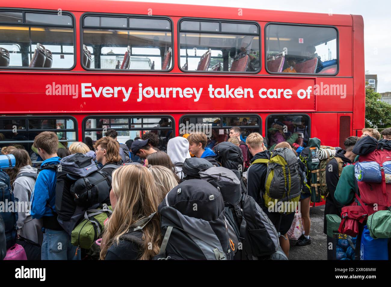 Junge Leute, die sich an Bord von Bussen anstellen, um sie zum Boardmasters Festival Newquay in Cornwall in Großbritannien zu bringen. Stockfoto