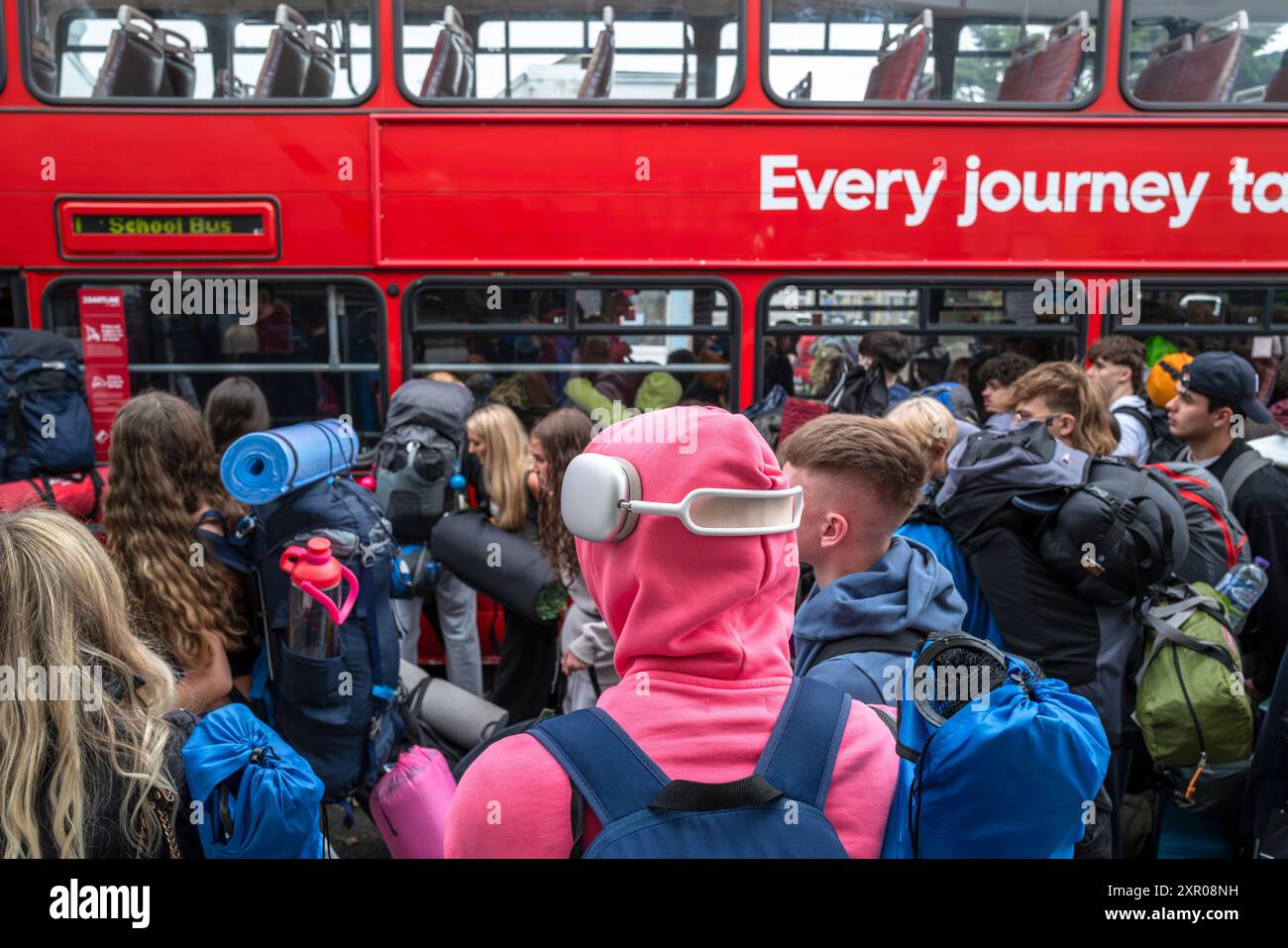 Junge Leute, die sich an Bord von Bussen anstellen, um sie zum Boardmasters Festival Newquay in Cornwall in Großbritannien zu bringen. Stockfoto
