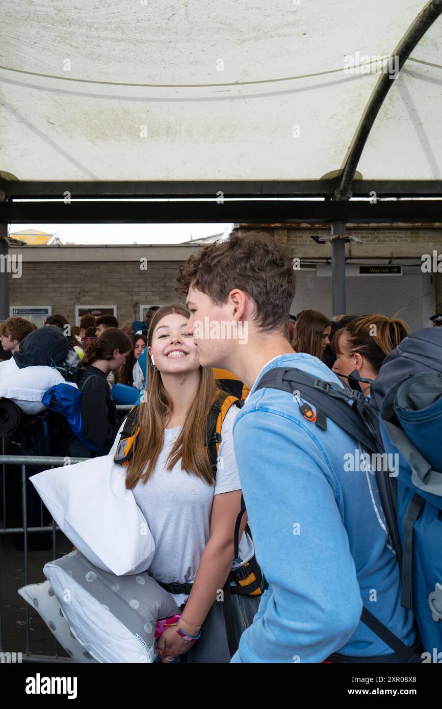 Begeisterte junge Leute, die am Bahnhof Newquay ankommen und sich an Bord der Busse schlangen, um sie zum Boardmasters Festival Newquay in Cornwall in Th zu bringen Stockfoto