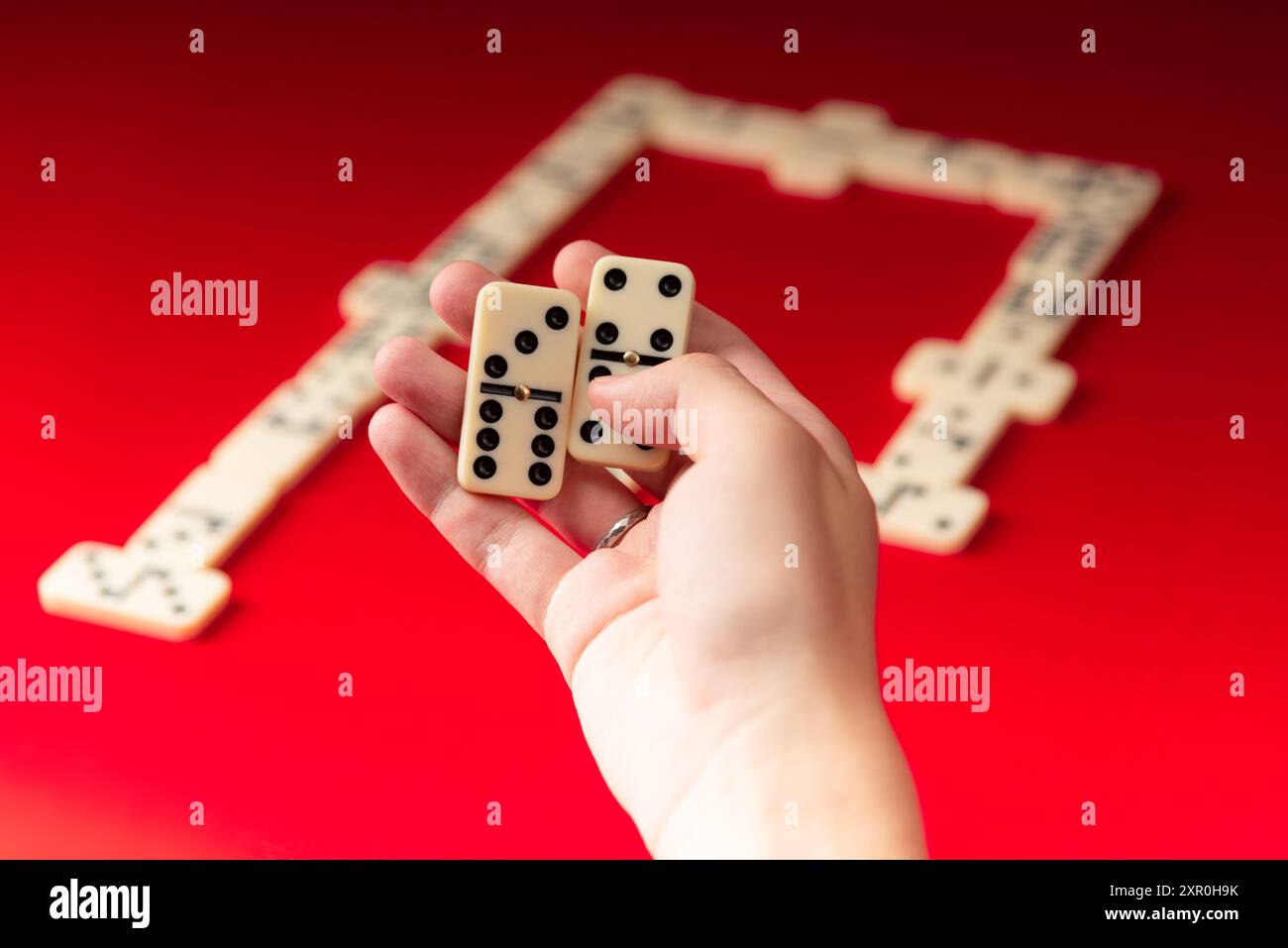 Domino-Spieler mit rechteckigen Acrylstücken. Brettspiel. Roter Hintergrund. Stockfoto