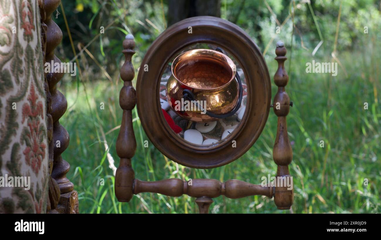 Reflexion eines Kessels und Runen im Spiegel. Ein Ritterstuhl. Stockfoto