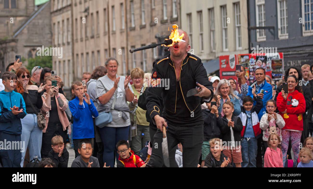 Royal Mile, Edinburgh, Schottland, Großbritannien. 8. August 2024. Dreich bewölkter Donnerstag auf der High Street für diejenigen, die Unterhaltung von den Street Performers suchen, um sie aufzumuntern. Im Bild: Tommy Fireboy schluckt ein Schwert und jongliert gleichzeitig mit Feuer. Quelle: Arch White/Alamy Live News. Stockfoto